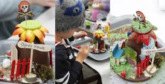 A table full of arts and crafts that kids get to make during the make it magical workshops.  They look like bright colourful fairy houses that the kids made.